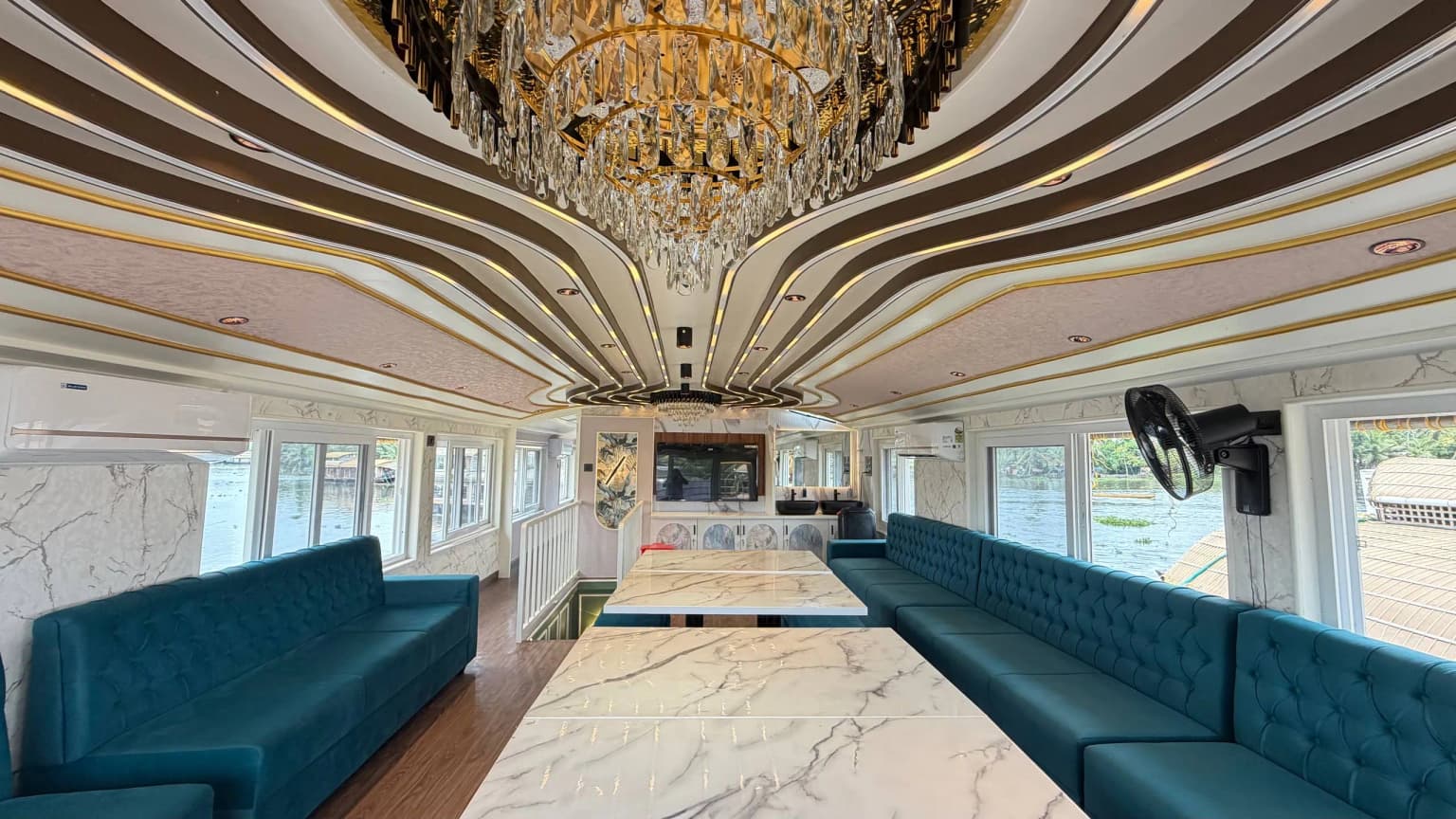 Spacious air-conditioned upper deck of Mahadeva houseboat with modern seating